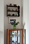 Vintage dresser and wall mounted shelf with ceramics in Bovey Tracey family home, Devon, England, UK