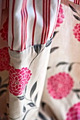 Pink floral patterned and striped fabric in Bovey Tracey family home, Devon, England, UK