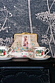 Vintage chinaware and purse with floral wallpaper in Bovey Tracey family home, Devon, England, UK