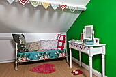 Daybed with dressing table in bright green bedroom of Bovey Tracey family home, Devon, England, UK