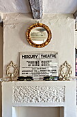 Theatre advertising with gilt framed mirror above original fireplace in Suffolk farmhouse, England, UK