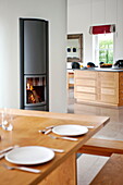 Beleuchtetes Feuer in offener Esszimmerküche, modernes Haus, Cornwall, England, UK
