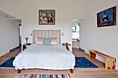 Blue rugs on floor of double bedroom with ensuite bathroom in contemporary home, Cornwall, England, UK