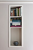 Recessed shelving for book storage in Padstow cottage, Cornwall, England, UK