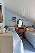 Light blue twin bedroom in attic of Padstow cottage, Cornwall, England, UK