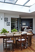 Wooden dining table and chairs with view to living room in London home, England, UK