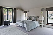 Light blue furnishings in double bedroom with access to terrace, London home, England, UK