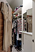 Variety of dresses hanging in dressing room of London home, England, UK