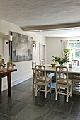 Dining table and chairs with modern artwork in contemporary Suffolk/Essex home, England, UK