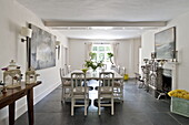 White dining table and chairs with modern artwork in contemporary Suffolk/Essex home, England, UK