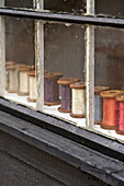 Spools of thread on windowsill of Suffolk/Essex home, England, UK