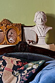 Historische Büste mit gerahmtem Kunstwerk und Wandteppichkissen in einem Haus in London, England, UK