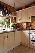White fitted units with checked splashback in kitchen of London home, England, UK