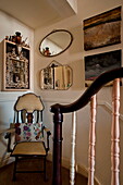 Vintage chair and mirrors on staircase in London home, England, UK
