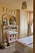 Dolls house and ornaments below single word 'LOVE' in London home, England, UK