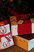 Three gift wrapped Christmas presents in Shropshire cottage, England, UK