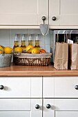 Bottles of beer and citrus fruit on worktop in kitchen of Shropshire cottage, England, UK