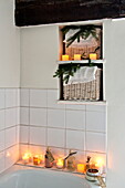 Lit candles in tiled white bathroom of Shropshire cottage, England, UKLit candles in tiled white bathroom of Shropshire cottage, England, UK