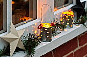 Lit candles and Christmas decoration on windowsill of Shropshire cottage, England, UK