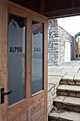 Open door and steps to paved garden exterior, Blagdon, Somerset, England, UK