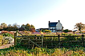 Ländliches Bauernhaus mit Zaun und großem Garten in Blagdon, Somerset, England, UK