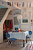 Open plan dining area with blue vintage chairs in Penzance cottage Cornwall England UK
