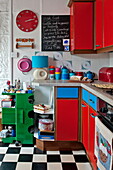 Red and blue retro style kitchen in Penzance cottage Cornwall England UK