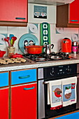 Red and blue fitted kitchen with baking on worktop in Penzance cottage Cornwall England UK