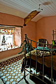 Trittbrett aus Messing mit Weihnachtsdekoration und gemustertem Teppich im pfirsichfarbenen Schlafzimmer des Hauses Tregaron in Wales (UK)