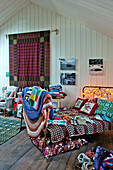 Blankets and artwork displayed on metal single bed in Tregaon shop interior Wales UK