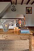 Books and lit candles on wooden coffee table in living room of Sherford barn conversion Devon UK