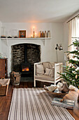 Christmas tree and armchair at fireside in Crantock home Cornwall England UK