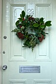 Floral Christmas wreath on pastel green front door of Penzance home England UK