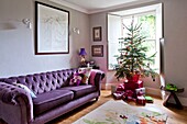 Christmas presents under tree in window of Penzance family living room Cornwall England UK