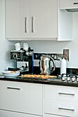 Kaffeemaschine und Wasserkocher mit Backwerk auf einem Tablett in der Küche eines Hauses in Wadebridge, North Cornwall UK