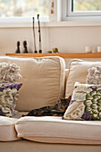 Floral cushions with cat on cream two seater sofa in Cornwall home UK