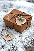 Als Geschenk verpackte Schachtel mit Schneeglöckchen (Galanthus) auf herzförmigen Geschenkanhängern London England UK
