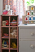 Ornaments and soft toys with white chest of drawers in girls' room Cambridge cottage England UK