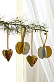Handmade Christmas ornaments hang on sprig of pine needle in London home England UK