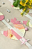 Fabric cockerel with Easter eggs on brown paper in Sussex garden England UK