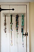 Necklaces hang on back of door in Edworth bedroom Bedfordshire England UK