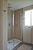 Glass shower cubicle with uncurtained window in Lechlade home Gloucestershire England UK
