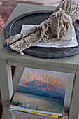 Knitting needles and wool with watercolour book on side table in beach house Cornwall England UK