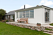 Croquet set and wooden seat on stone terrace of Cornwall beach house England UK