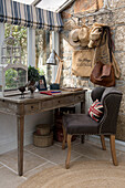 Brown chair at wooden desk with hatrack in window of Penzance farmhouse Cornwall England UK