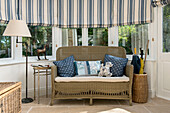 Blue spotted cushions on wicker sofa in bay window of Penzance farmhouse Cornwall England UK