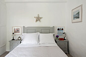 Star above double bed with grey painted cabinets in Penzance farmhouse Cornwall England UK