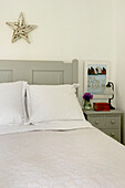 Star above double bed with painted cabinet in Penzance farmhouse Cornwall England UK