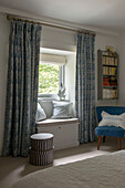 Blau gemusterte Vorhänge und Fensterbank im Schlafzimmer eines Bauernhauses in Penzance, Cornwall, England