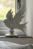 Metallic bird on windowsill in Penzance farmhouse Cornwall England UK